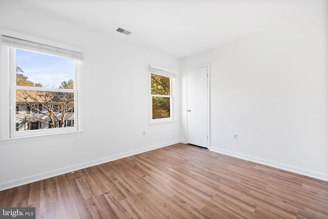 unfurnished room with hardwood / wood-style flooring and plenty of natural light