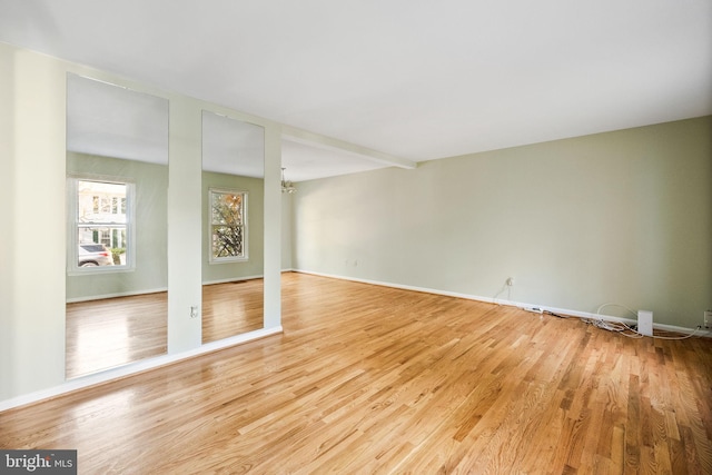 spare room featuring light hardwood / wood-style flooring and a chandelier