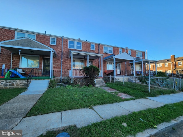 multi unit property featuring a porch and a front yard