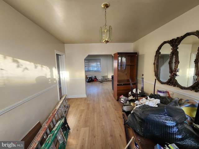 hallway featuring light hardwood / wood-style floors and an inviting chandelier