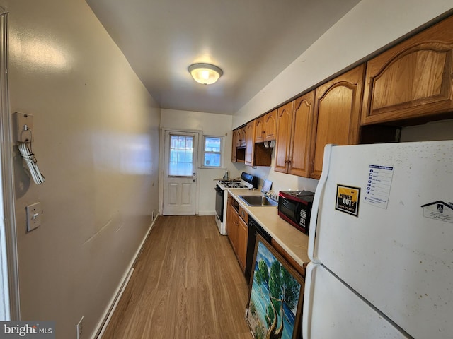 kitchen with white appliances and light hardwood / wood-style flooring