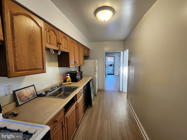 kitchen with wood-type flooring, black appliances, and sink