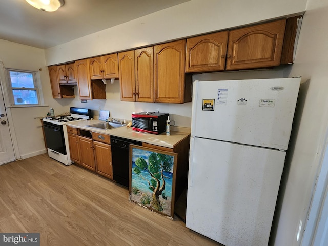 kitchen with white appliances, light hardwood / wood-style flooring, and sink