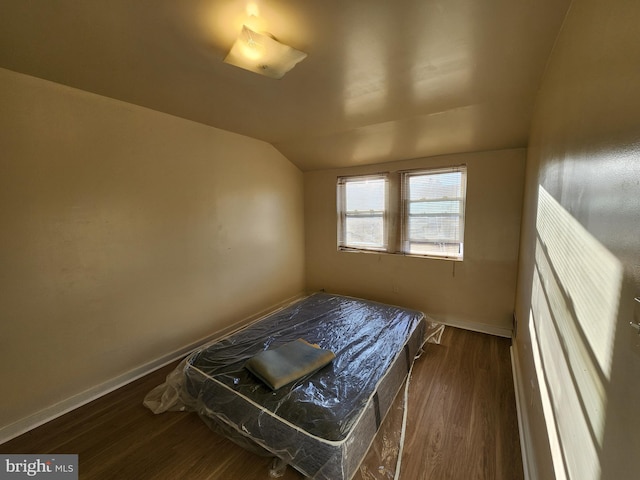 bedroom featuring lofted ceiling and dark hardwood / wood-style flooring