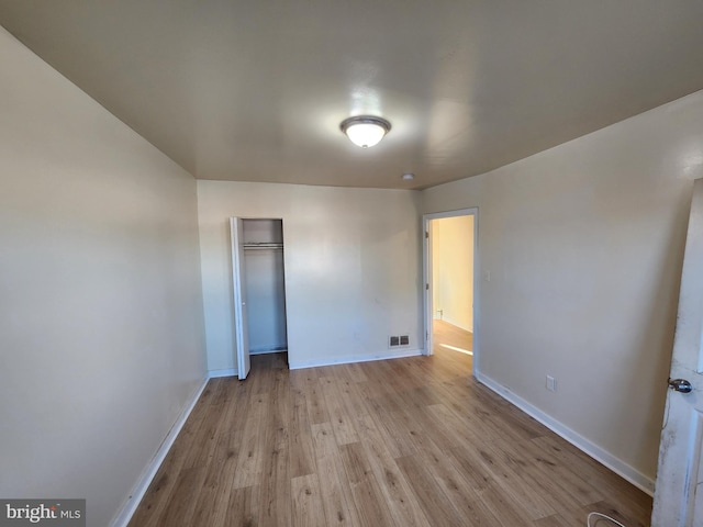 unfurnished bedroom with a closet and light wood-type flooring