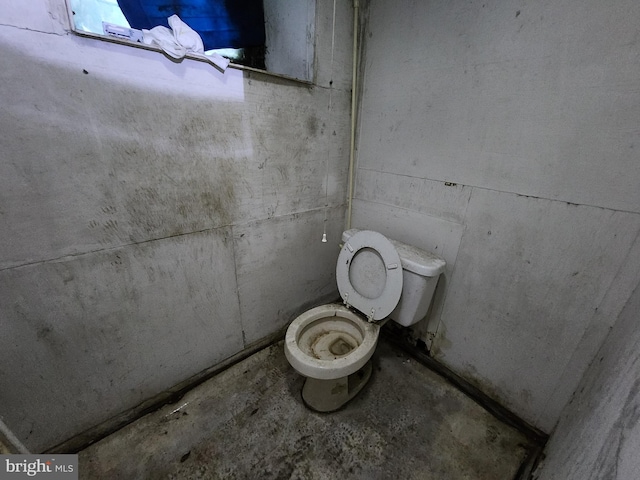 bathroom featuring toilet and concrete flooring