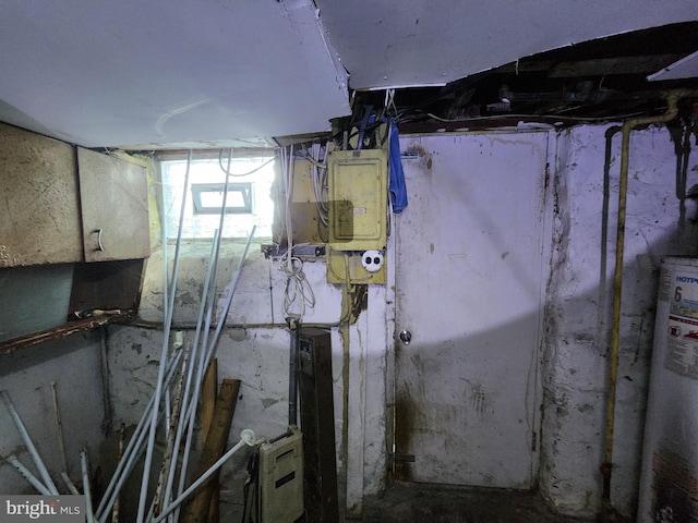 basement featuring electric panel and water heater