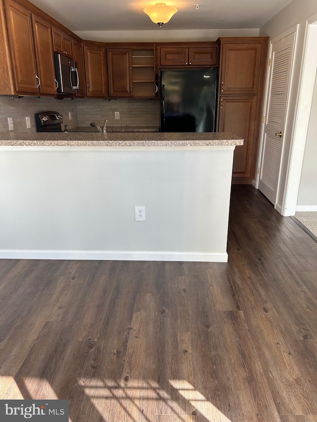 kitchen featuring sink, black appliances, dark hardwood / wood-style floors, and backsplash