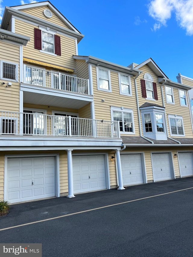 view of front facade featuring a garage and a balcony