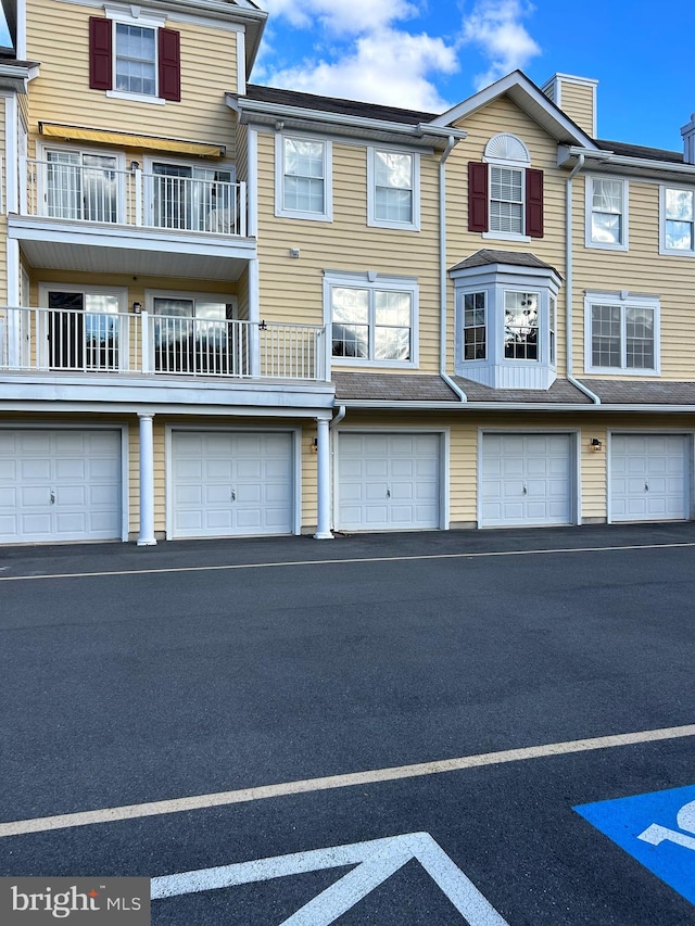 exterior space featuring a garage and a balcony