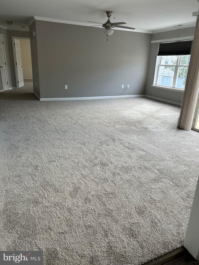 carpeted empty room featuring ornamental molding and ceiling fan