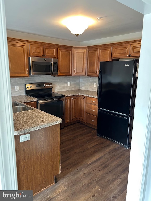 kitchen featuring stainless steel appliances, tasteful backsplash, and dark hardwood / wood-style floors