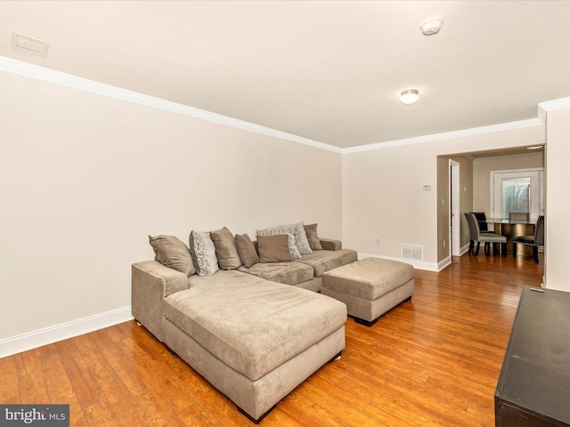 living room featuring wood-type flooring and ornamental molding