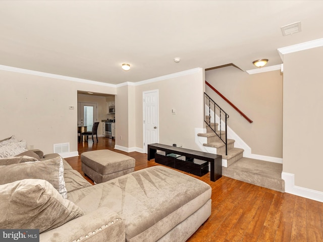 living room with hardwood / wood-style flooring and crown molding