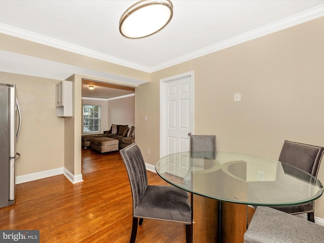 dining area with crown molding and hardwood / wood-style floors