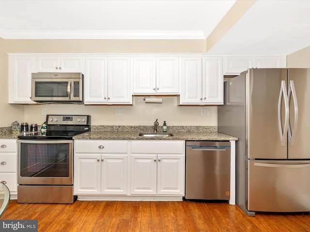 kitchen featuring light stone counters, sink, light hardwood / wood-style floors, and appliances with stainless steel finishes