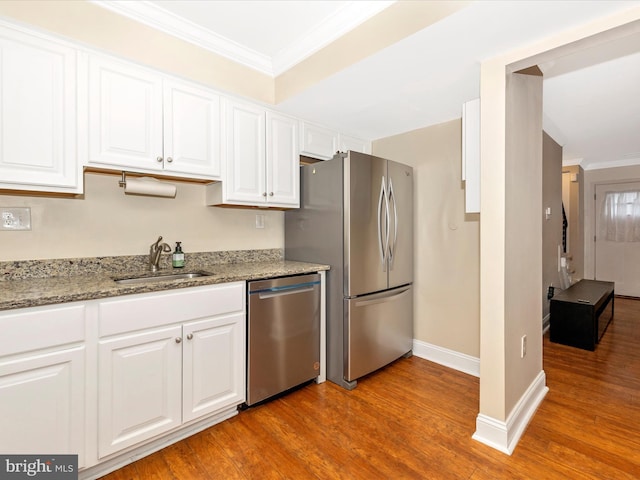 kitchen featuring light stone countertops, appliances with stainless steel finishes, sink, light hardwood / wood-style flooring, and white cabinets