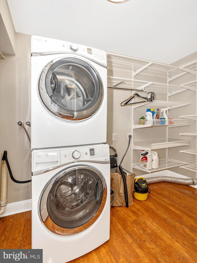 washroom featuring stacked washer / dryer and wood-type flooring