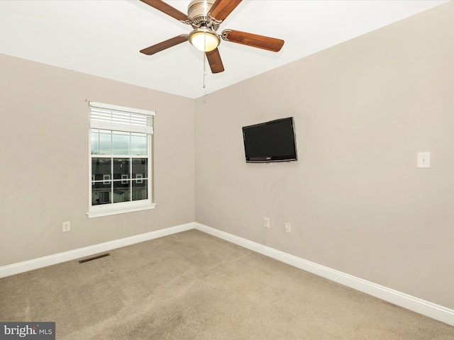 carpeted spare room featuring ceiling fan