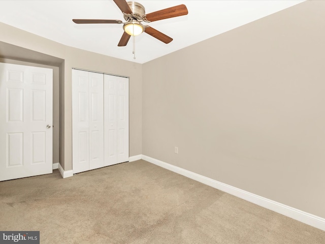 unfurnished bedroom featuring a closet, light colored carpet, and ceiling fan