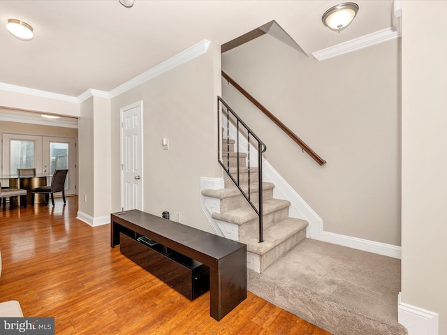 interior space featuring hardwood / wood-style flooring, ornamental molding, and french doors