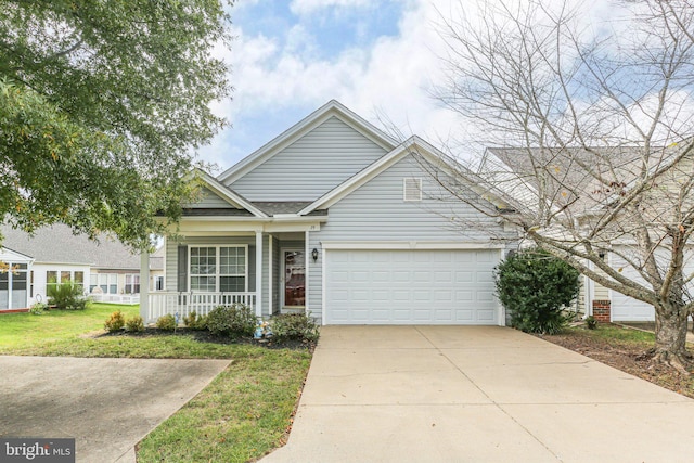 view of front of home with a front yard, a garage, and covered porch