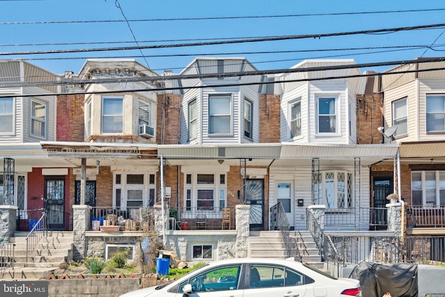 townhome / multi-family property featuring cooling unit and covered porch