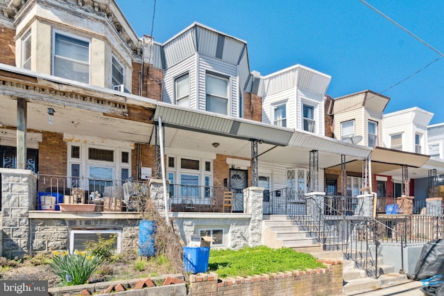 townhome / multi-family property featuring covered porch