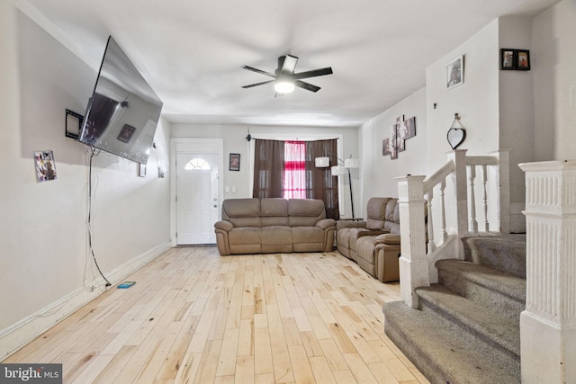 living room featuring ceiling fan, stairs, wood finished floors, and baseboards