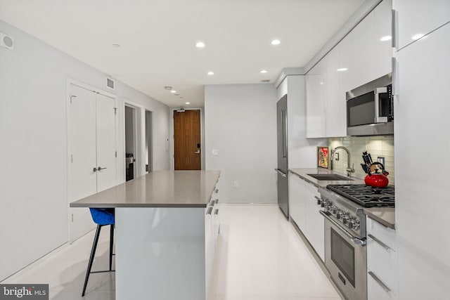 kitchen featuring white cabinetry, a center island, premium appliances, and modern cabinets