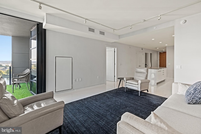 living room featuring rail lighting, tile patterned flooring, and visible vents