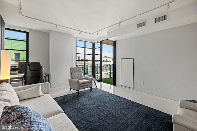 tiled living area featuring track lighting, visible vents, and floor to ceiling windows