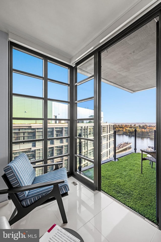 sunroom featuring a water view