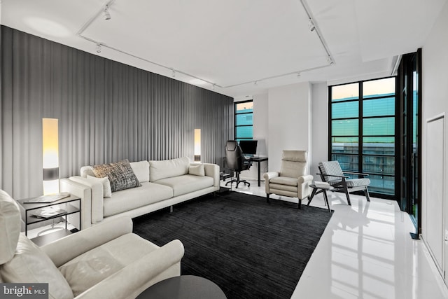 living area with a wall of windows, tile patterned flooring, and rail lighting