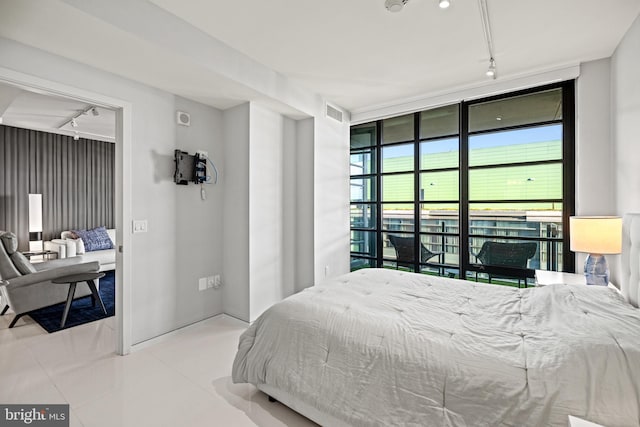 tiled bedroom with expansive windows and track lighting