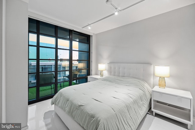 bedroom with concrete flooring and track lighting