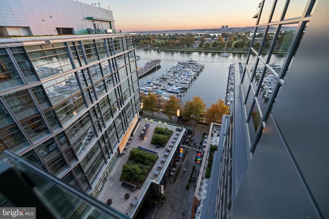 aerial view at dusk featuring a water view