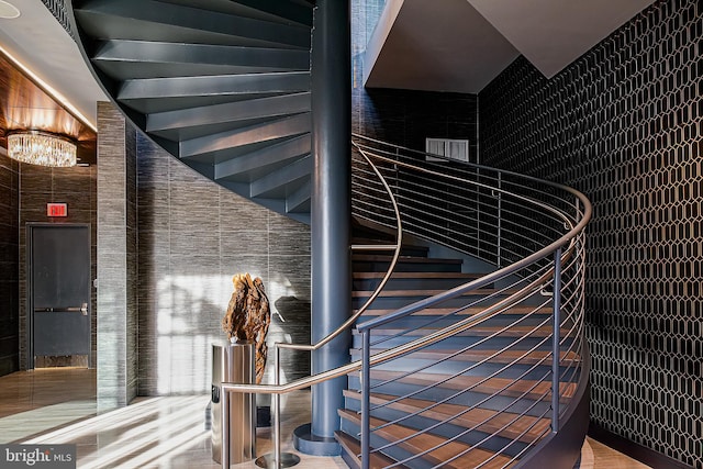 stairs with an inviting chandelier