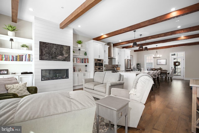 living room featuring an inviting chandelier, a fireplace, beam ceiling, and dark wood-type flooring