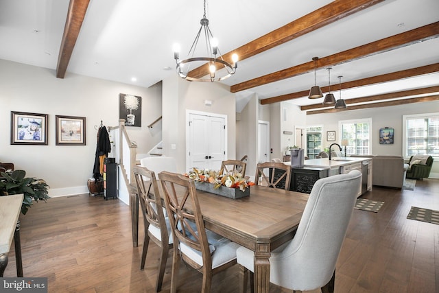 dining area featuring beam ceiling, sink, an inviting chandelier, and dark hardwood / wood-style flooring