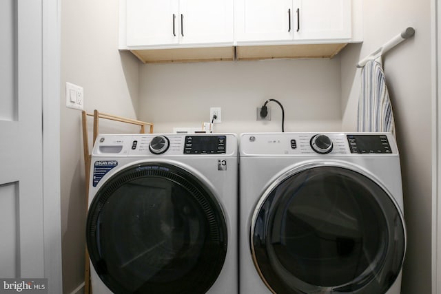 laundry room with washer and dryer and cabinets