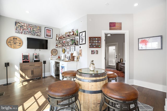 bar featuring dark hardwood / wood-style floors and white cabinetry