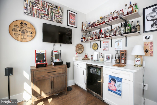 bar with wine cooler, white cabinetry, and dark hardwood / wood-style flooring