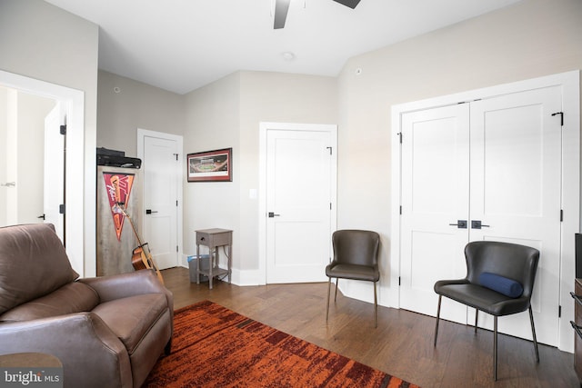 living area featuring ceiling fan and dark wood-type flooring