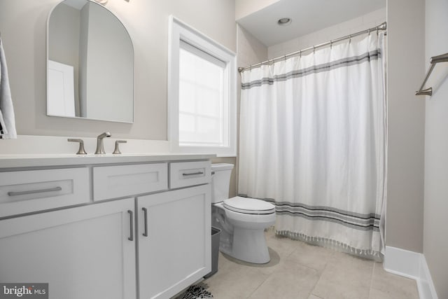 bathroom with tile patterned flooring, walk in shower, vanity, and toilet