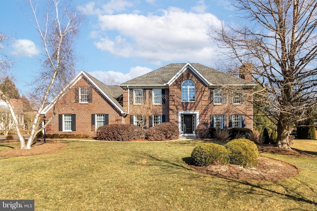 view of front of home with a front lawn and brick siding