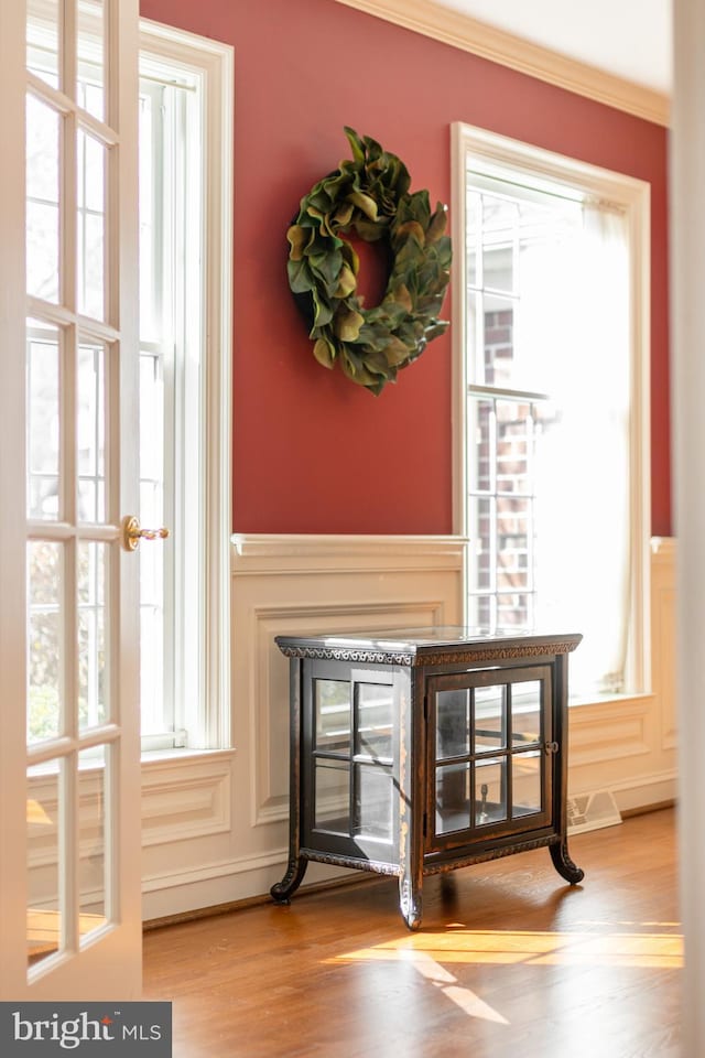 room details featuring wood finished floors, a multi sided fireplace, and crown molding