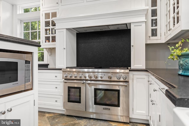 kitchen with white cabinetry, premium range hood, and appliances with stainless steel finishes