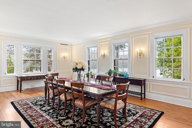 dining room featuring light wood-type flooring and crown molding