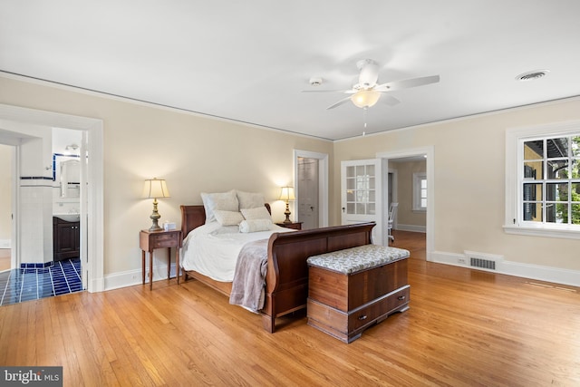 bedroom with ensuite bath, ceiling fan, ornamental molding, and light wood-type flooring